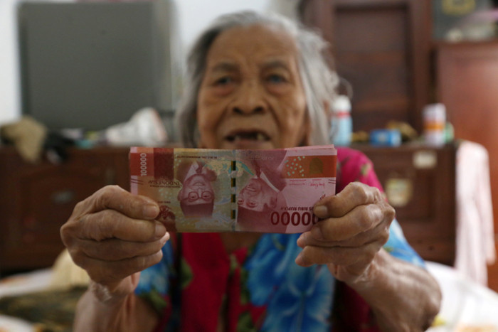 Petugas Pos Indonesia menyalurkan Bantuan Sosial Tunai (BST) kepada lansia di Kedung Sroko, Surabaya, Jawa Timur, Senin (2/8/2021).