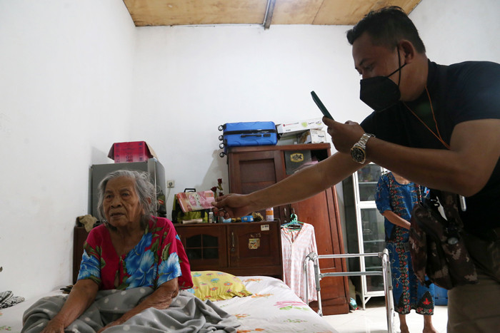 Petugas Pos Indonesia menyalurkan Bantuan Sosial Tunai (BST) kepada lansia di Kedung Sroko, Surabaya, Jawa Timur, Senin (2/8/2021).