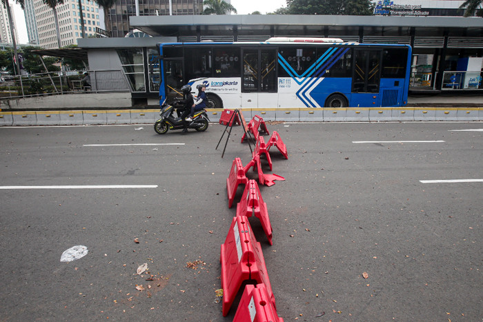 Pengendara sepeda motor menerobos penyekatan di Jalan Jendral Sudirman, Senayan, Jakarta Pusat, Senin (2/8/2021).