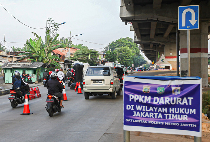 Petugas melakukan pemeriksaan Surat Tanda Registrasi Pekerja kepada pengendara yang melewati penyekatan di Pos Lampiri, Kalimalang, Senin (2/8/2021).