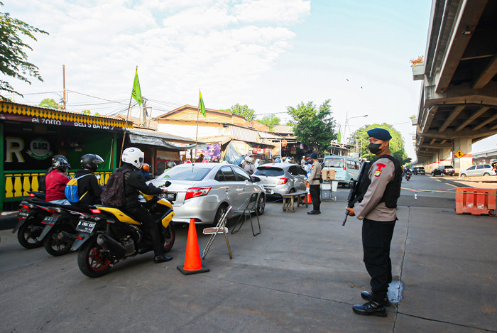 Petugas melakukan pemeriksaan Surat Tanda Registrasi Pekerja kepada pengendara yang melewati penyekatan di Pos Lampiri, Kalimalang, Senin (2/8/2021).