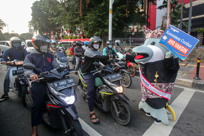 Maskot Hari Konsumen Nasional (HARKONAS) Si Enda melakukan aksi kampanye kepada pengendara yang melintas di kawasan Tugu Tani, Jakarta Pusat, Selasa (3/8/2021).