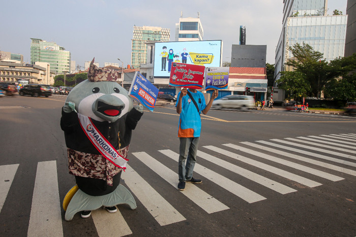 Maskot Hari Konsumen Nasional (HARKONAS) Si Enda melakukan aksi kampanye kepada pengendara yang melintas di kawasan Tugu Tani, Jakarta Pusat, Selasa (3/8/2021).