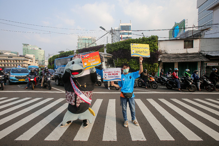 Maskot Hari Konsumen Nasional (HARKONAS) Si Enda melakukan aksi kampanye kepada pengendara yang melintas di kawasan Tugu Tani, Jakarta Pusat, Selasa (3/8/2021).
