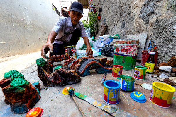 Bang lani (55) membuat miniatur hiasan untuk akuarium di rumahnya, Jalan Adam, Rawa Belong, Jakarta Barat, Selasa (3/8/2021).