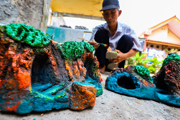 Bang lani (55) membuat miniatur hiasan untuk akuarium di rumahnya, Jalan Adam, Rawa Belong, Jakarta Barat, Selasa (3/8/2021).