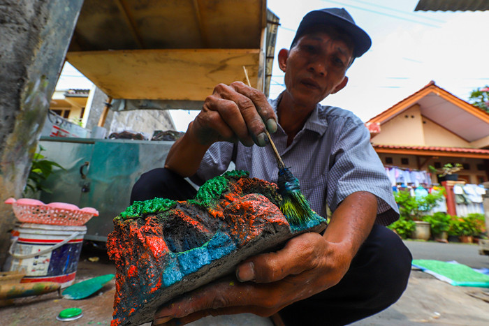 Bang lani (55) membuat miniatur hiasan untuk akuarium di rumahnya, Jalan Adam, Rawa Belong, Jakarta Barat, Selasa (3/8/2021).