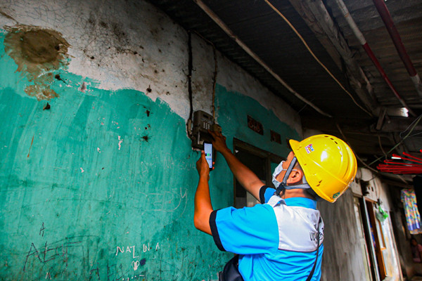 Petugas PLN melakukan pemeriksaan kWh meter milik warga di Kampung Tengah, Kramat Jati, Jakarta Timur, Kamis (5/8/2021).