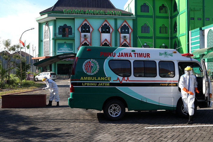 Relawan Satgas Covid-19 PWNU Jatim menyiapkan peralatan pemulasaran dan pemakaman jenazah Covid-19 di halaman Kantor PWNU, Surabaya, Kamis (5/8/2021).
