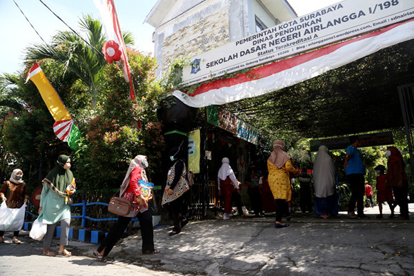 Sejumlah siswa dan walimurid meletakkan donasi berupa kebutuhan pokok di depan gerbang sekolah SD Negeri 1 Airlangga, Surabaya, Jawa Timur, Jumat (6/8/2021).