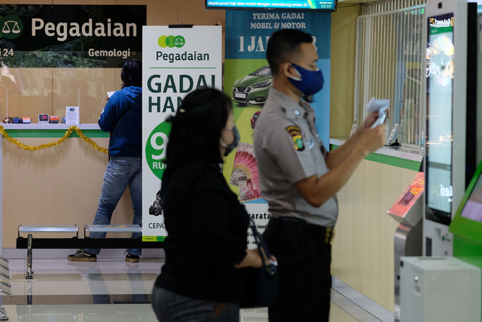 Nasabah melakukan transaksi di counter kantor cabang Pegadaian Kebayoran Baru, Jakarta, Jumat, (6/8/2021).