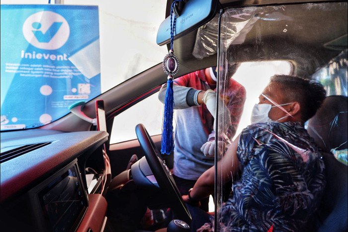 Petugas medis menyuntikan vaksin kepada pengunjung yang akan masuk ke tempat wisata Pantai Akkarena, Makassar, Jalan Metro Tanjung Bunga, Jumat (6/8/2021).