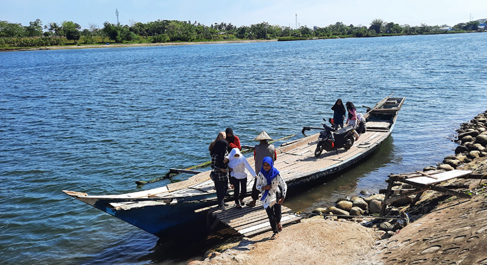 Warga menggunakan perahu penyebrangan di Sungai Jeneberang yang berbatasan langsung Kabupaten Gowa dan Makassar, Minggu (8/8/2021).