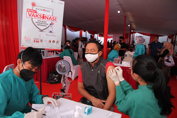 Warga DKI Jakarta mengikuti vaksinasi di Sentra Vaksinasi Bank DKI dosis ke-2 di Kantor Layanan Bank DKI Juanda, Jakarta Pusat, Minggu (8/8/2021).