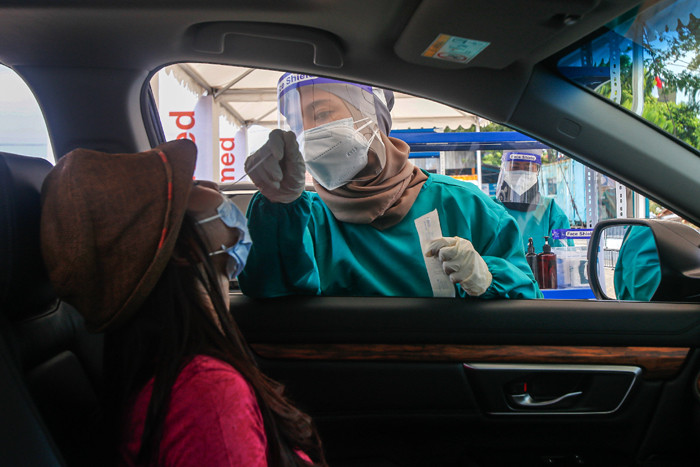 Warga menjalani swab test antigen secara drive thru di Altomed, Kelapa Gading, Jakarta Utara, Senin (9/8/2021).