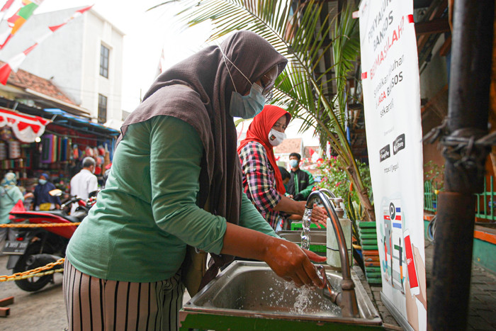 Pengunjung menunjukan sertifikat bukti telah melakukan vaksin kepada petugas sebelum masuk ke Gedung Pasar Jatinegara, Jakarta Timur, Senin (9/8/2021).