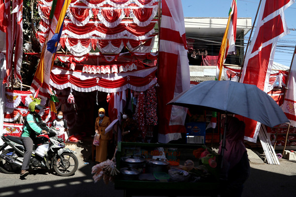 Perajin menjahit Bendera Merah Putih di kampung perajin bendera kawasan Darmo Kali, Surabaya, Jawa Timur, Senin (9/8/2021).