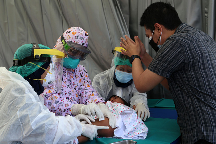 Dokter Spesialis Anak dr. Dini Adityarini memberikan vaksin pada anak ketika melayani vaksinasi secara drive thru di RS Kendangsari Merr, Selasa (10/8/2021).
