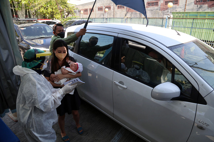 Dokter Spesialis Anak dr. Dini Adityarini memberikan vaksin pada anak ketika melayani vaksinasi secara drive thru di RS Kendangsari Merr, Selasa (10/8/2021).