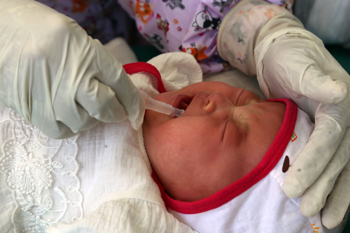 Dokter Spesialis Anak dr. Dini Adityarini memberikan vaksin pada anak ketika melayani vaksinasi secara drive thru di RS Kendangsari Merr, Selasa (10/8/2021).