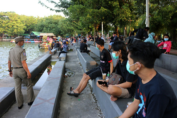 Petugas Satpol PP berkeliling di kawasan danau Sunter, Jakarta, Rabu (11/8/2021).