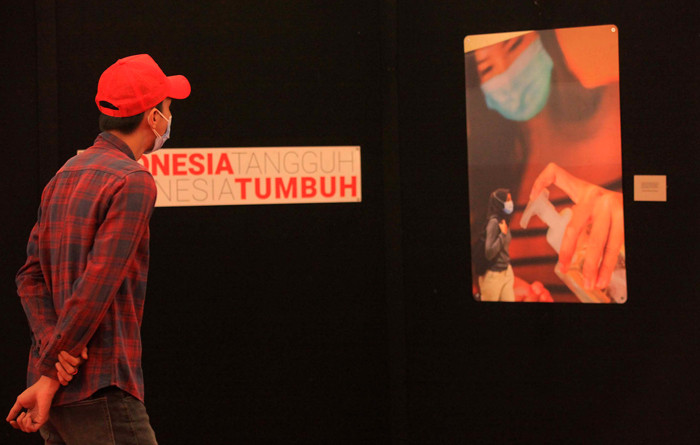 Pengunjung melihat foto yang dipamerkan dalam pameran foto jurnalistik Indonesia Tangguh Indonesia Tumbuh di Mal Central Park, Jakarta, Rabu (11/8/2021).