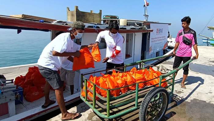 Warga pesisir Pulau Panjang mendapatkan paket bantuan sembako dari BNI di Serang, Banten, Kamis (12/8/2021).