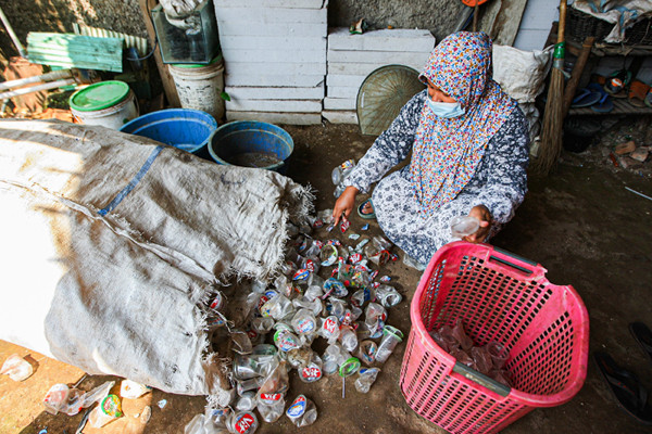 Pengepul saat memilah sampah kemasan di Kampung Ciketing, Kelurahan Sumur Batu, Kecamatan Bantargebang, Kota Bekasi, Kamis (12/8/2021).