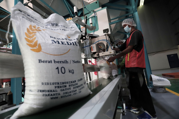 Pekerja mengoperasikan mesin Rice To Rice (RTR) untuk mengisi karung beras bantuan PPKM sebelum didistribusikan ke masyarakat di Jakarta, Jumat (13/8/2021).