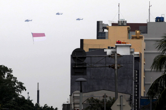 Sejumlah helikopter TNI Angkatan Udara terbang membawa bendera Merah Putih di Jakarta, Jumat (13/8/2021).