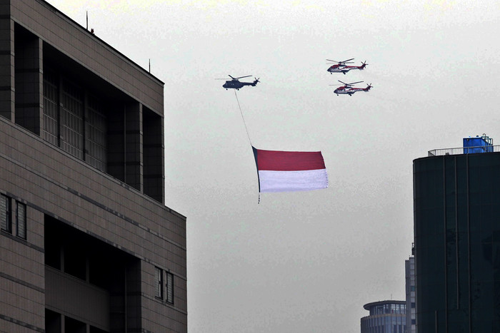 Sejumlah helikopter TNI Angkatan Udara terbang membawa bendera Merah Putih di Jakarta, Jumat (13/8/2021).