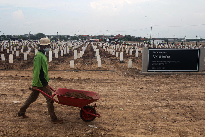 Petugas memindahkan tanah untuk merapihkan makam di Tempat Pemakaman Umum (TPU) Rorotan, Jakarta Utara, Jumat (13/8/2021).