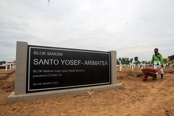 Petugas memindahkan tanah untuk merapihkan makam di Tempat Pemakaman Umum (TPU) Rorotan, Jakarta Utara, Jumat (13/8/2021).