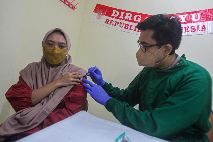 Petugas menyuntikan vaksin dosis ketiga atau booster kepada tenaga kesehatan di (nakes) di RSUD Matraman, Jakarta Timur, Jumat (13/8/2021).