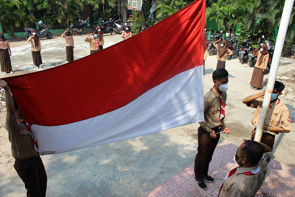 Siswa-siswi SMP dan SMK Syahid melakukan upacara peringatan Hari Pramuka ke-60 di kawasan Cilincing, Jakarta Utara, Sabtu (14/8/2021).