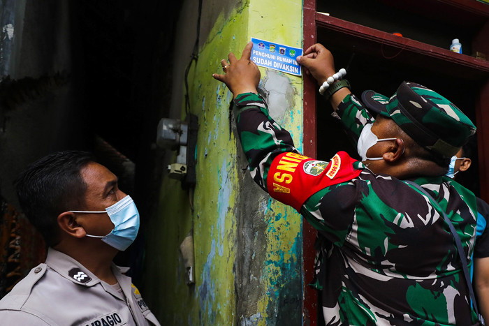 Personel Satuan Tugas Penanganan Covid-19 menempelkan stiker vaksin di rumah warga, Kelurahan Sunter Agung, Tanjung Priok, Jakarta Utara. Jumat (13/8/2021).