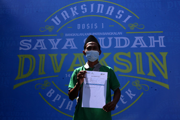 Warga mendapatkan suntikan vaksin Covid-19 ketika mengikuti vaksinasi massal yang dihelat BP Jamsostek di Madura, Jawa Timur, Sabtu (14/8/2021).