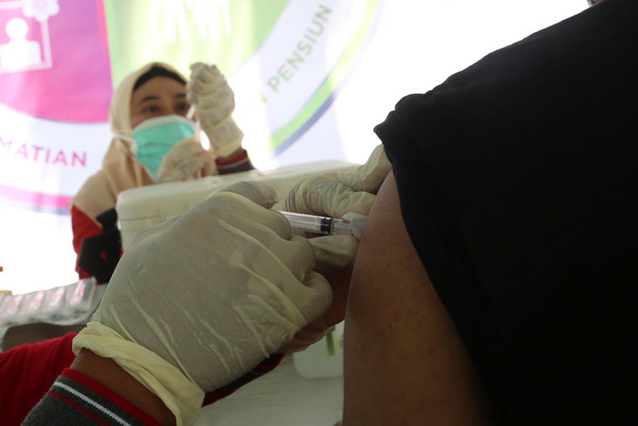Warga mendapatkan suntikan vaksin Covid-19 ketika mengikuti vaksinasi massal yang dihelat BP Jamsostek di Madura, Jawa Timur, Sabtu (14/8/2021).