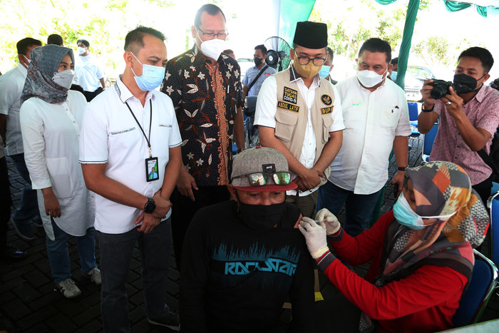 Warga mendapatkan suntikan vaksin Covid-19 ketika mengikuti vaksinasi massal yang dihelat BP Jamsostek di Madura, Jawa Timur, Sabtu (14/8/2021).