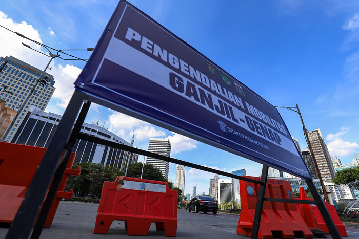 Petugas kepolisian saat mengatur kendaraan yang melintas di Jalan Jenderal Sudirman, Jakarta Pusat, Minggu (15/8/2021).