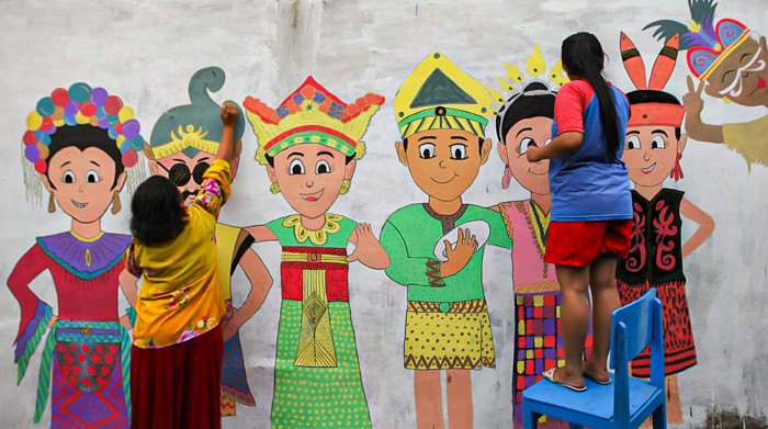 Winy bersama keluarganya saat membuat mural bertema keberagaman budaya Indonesia di Jalan Annur, Lubang Buaya, Jakarta Timur, Minggu (15/8/2021).