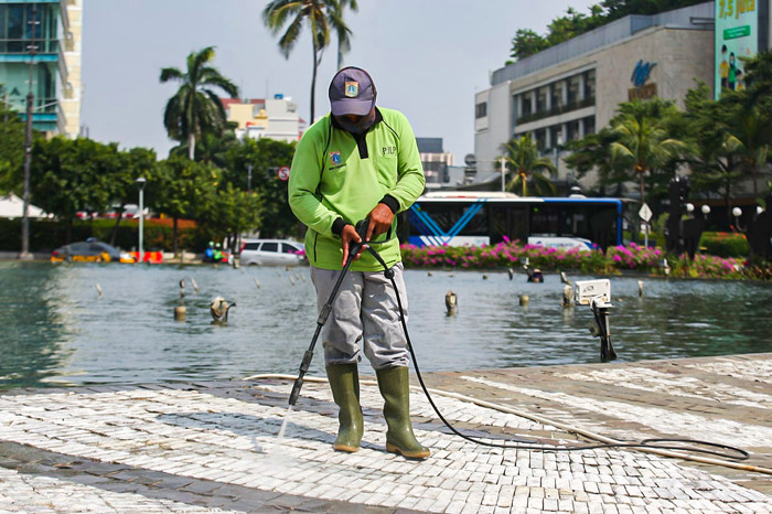 Petugas membersihkan kolam Patung Selamat Datang di kawasan Bundaran HI, Jakarta Pusat, Senin (16/8/2021).