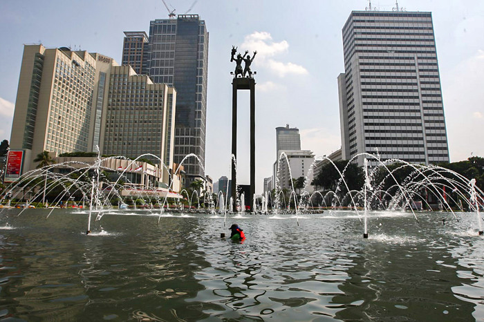 Petugas membersihkan kolam Patung Selamat Datang di kawasan Bundaran HI, Jakarta Pusat, Senin (16/8/2021).