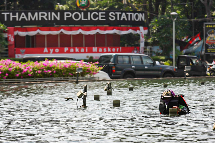 Petugas membersihkan kolam Patung Selamat Datang di kawasan Bundaran HI, Jakarta Pusat, Senin (16/8/2021).