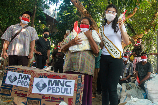 Miss Indonesia 2020 Pricilia Carla Yules memberikan bantuan kepada warga yang tinggal di bawah kolong Stasiun Juanda, Jakarta Pusat, Senin (16/8/2021).