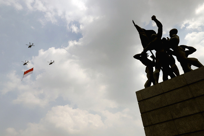 Pesawat tempur Angkatan Udara dan Helikopter Angkatan Darat membawa bendera merah putih di kawasan Monumen Nasional (Monas), Jakarta, Selasa (17/8/2021).