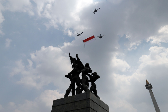 Pesawat tempur Angkatan Udara dan Helikopter Angkatan Darat membawa bendera merah putih di kawasan Monumen Nasional (Monas), Jakarta, Selasa (17/8/2021).