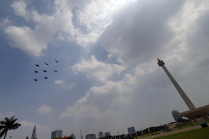 Pesawat tempur Angkatan Udara dan Helikopter Angkatan Darat membawa bendera merah putih di kawasan Monumen Nasional (Monas), Jakarta, Selasa (17/8/2021).