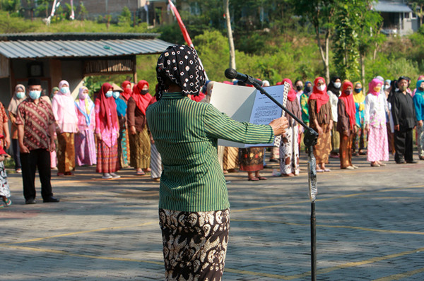 Petugas dan puluhan warga mengenakan pakaian adat Jawa saat mengikuti upacara peringatan HUT ke-76 Kemerdekaan RI di Kampung Jawi, Selasa (17/8/2021).