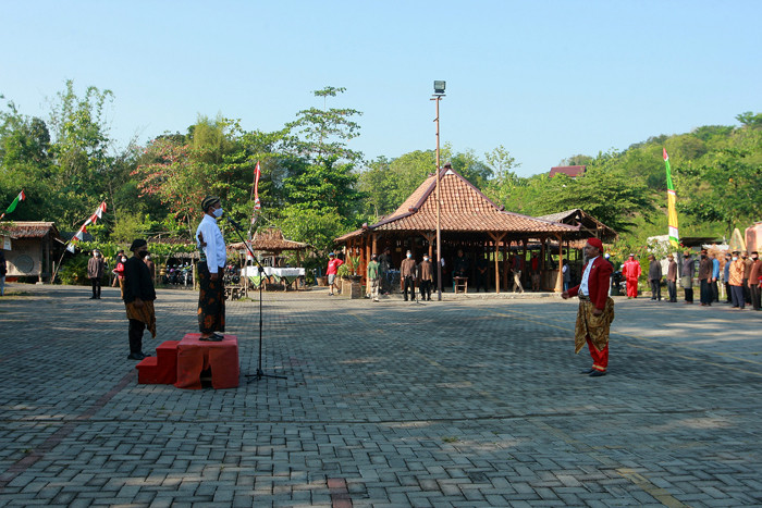 Petugas dan puluhan warga mengenakan pakaian adat Jawa saat mengikuti upacara peringatan HUT ke-76 Kemerdekaan RI di Kampung Jawi, Selasa (17/8/2021).